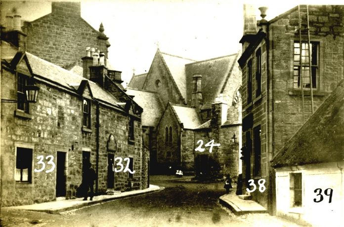 View looking up Lugar Street towards Old Cumnock Old Church in the early 1900s; the Tupp Inn is the building on the left (numbered 33 and 32)