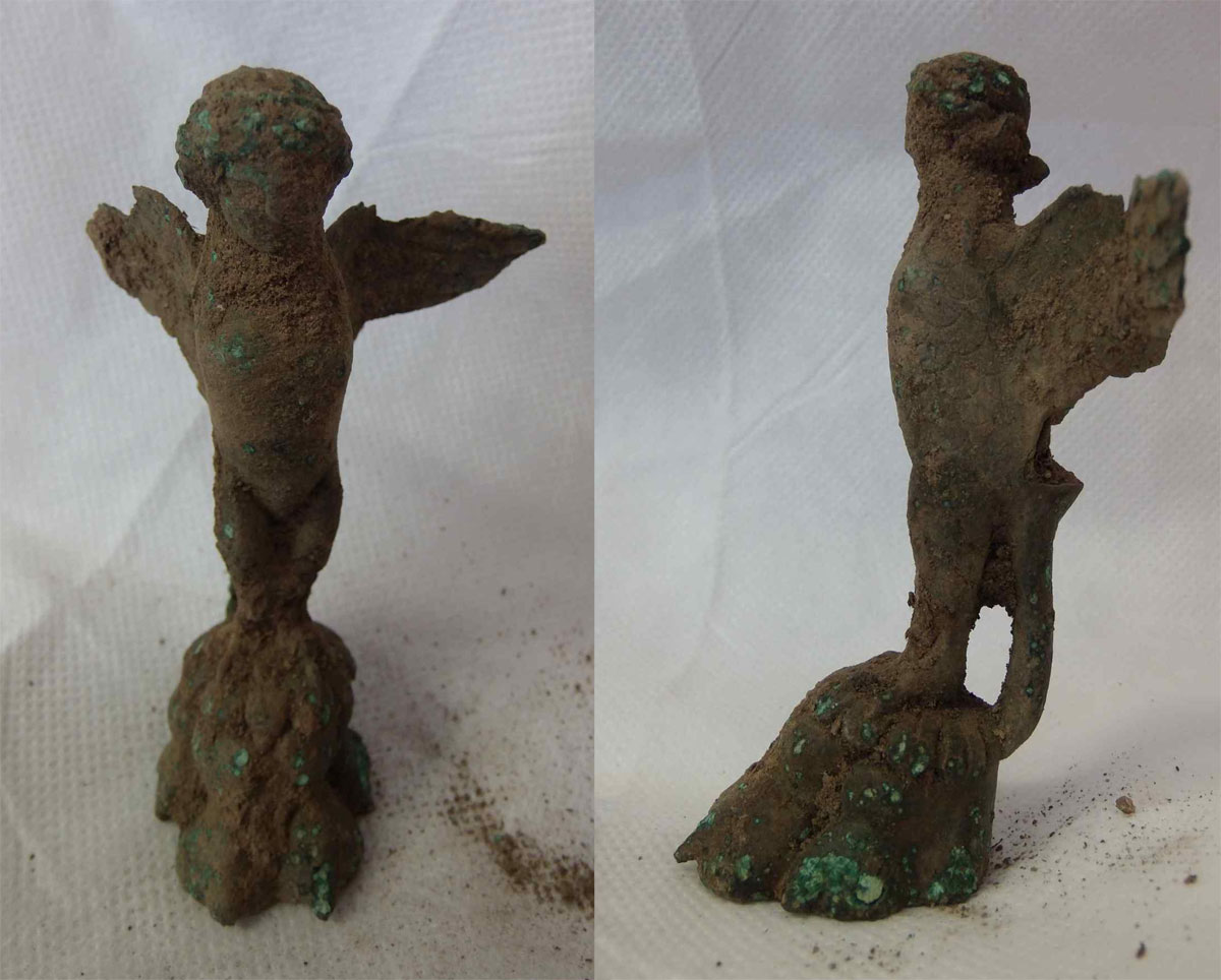 The image shows the figurine, before cleaning and conservation (from the front and in profile). Colchester Archaeology Trust