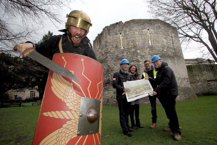 Gladiator Victorix from the Eboracum Roman Festival (left) urges (l-r) City of York Council’s Archaeologist John Oxley and York Museums Trust Curator Emma Williams, Cllr Nigel Ayre and Mitchell Pollington of AOC Archaeology Group to find the lost amphitheatre through Ex Factum.