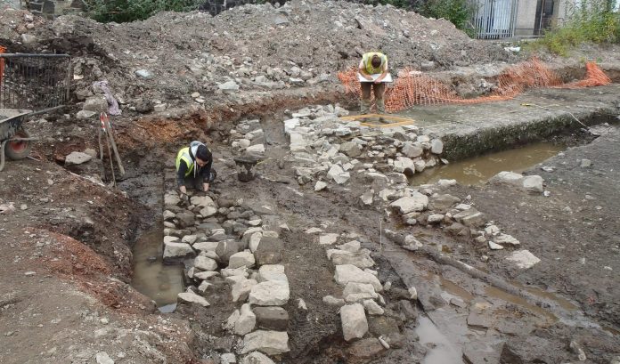 The friary wall being cleaned and recorded by GUARD Archaeologists © GUARD Archaeology Ltd.