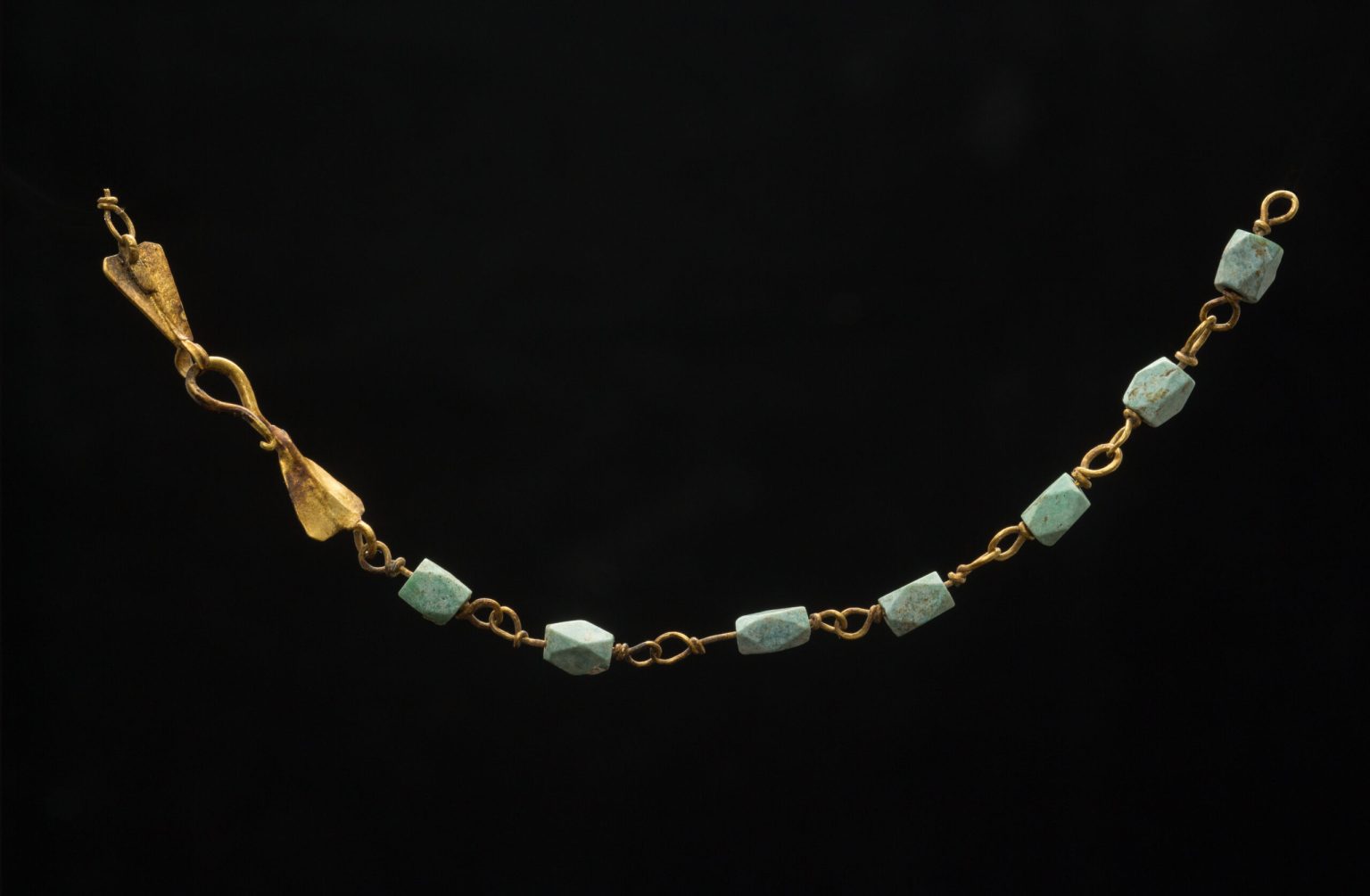 Wealth is further attested to by the discovery of gold jewellery at the site. Evidence of wear and modification suggests that this necklace of gold filigree double-loop links threaded with polyhedral faceted beads of variscite is an heirloom piece modified into a bracelet for a child.